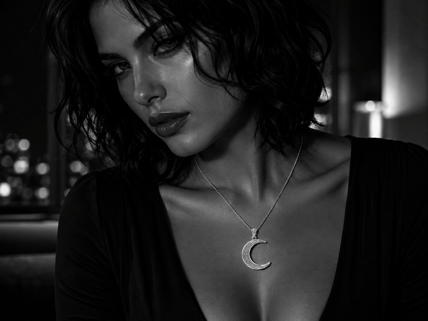 Sultry woman wearing a Celtic crescent moon pendant in a black-and-white neo-noir portrait