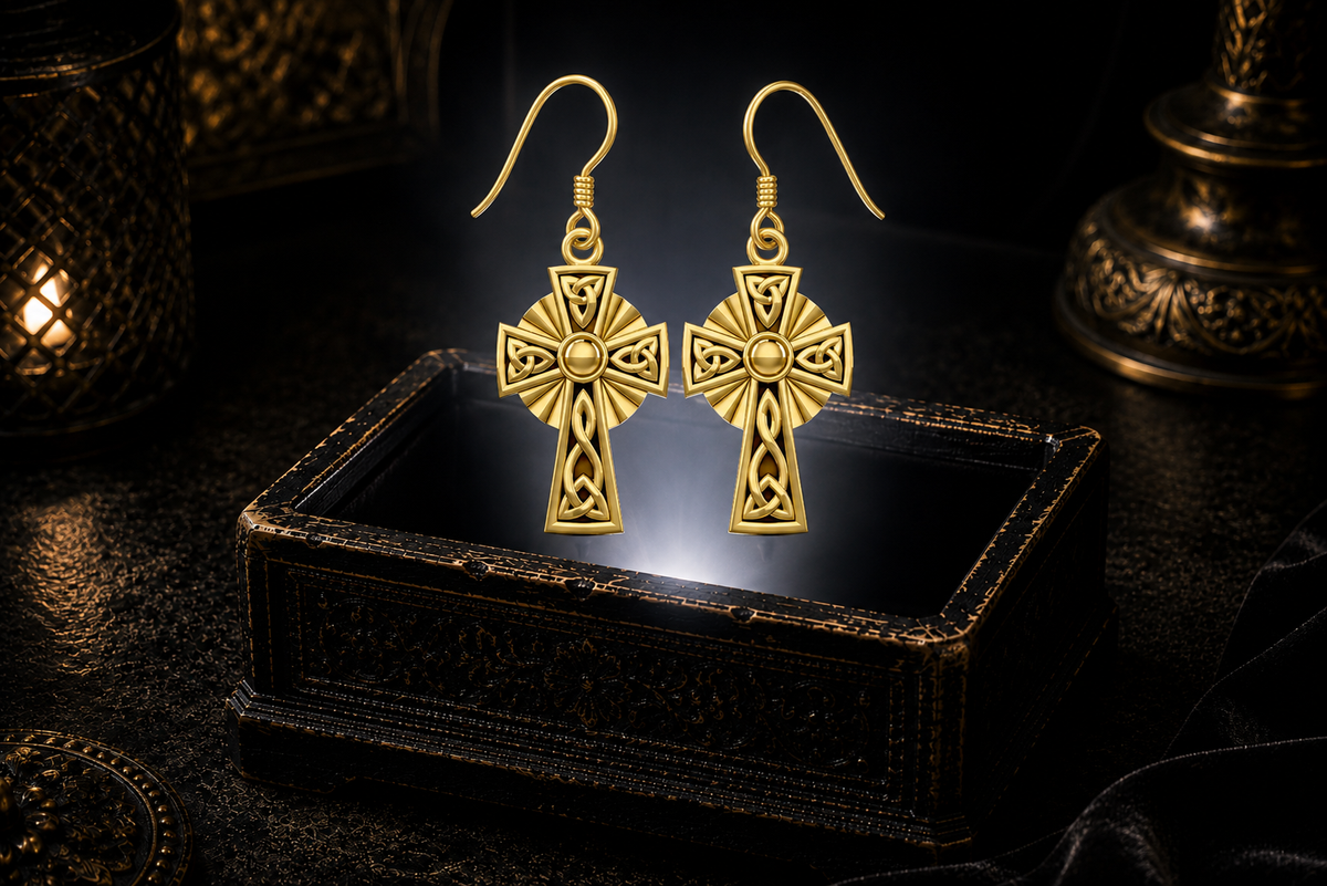 14K solid gold Celtic Cross knotwork earrings floating above a glowing ornate jewelry box in a dark luxury setting