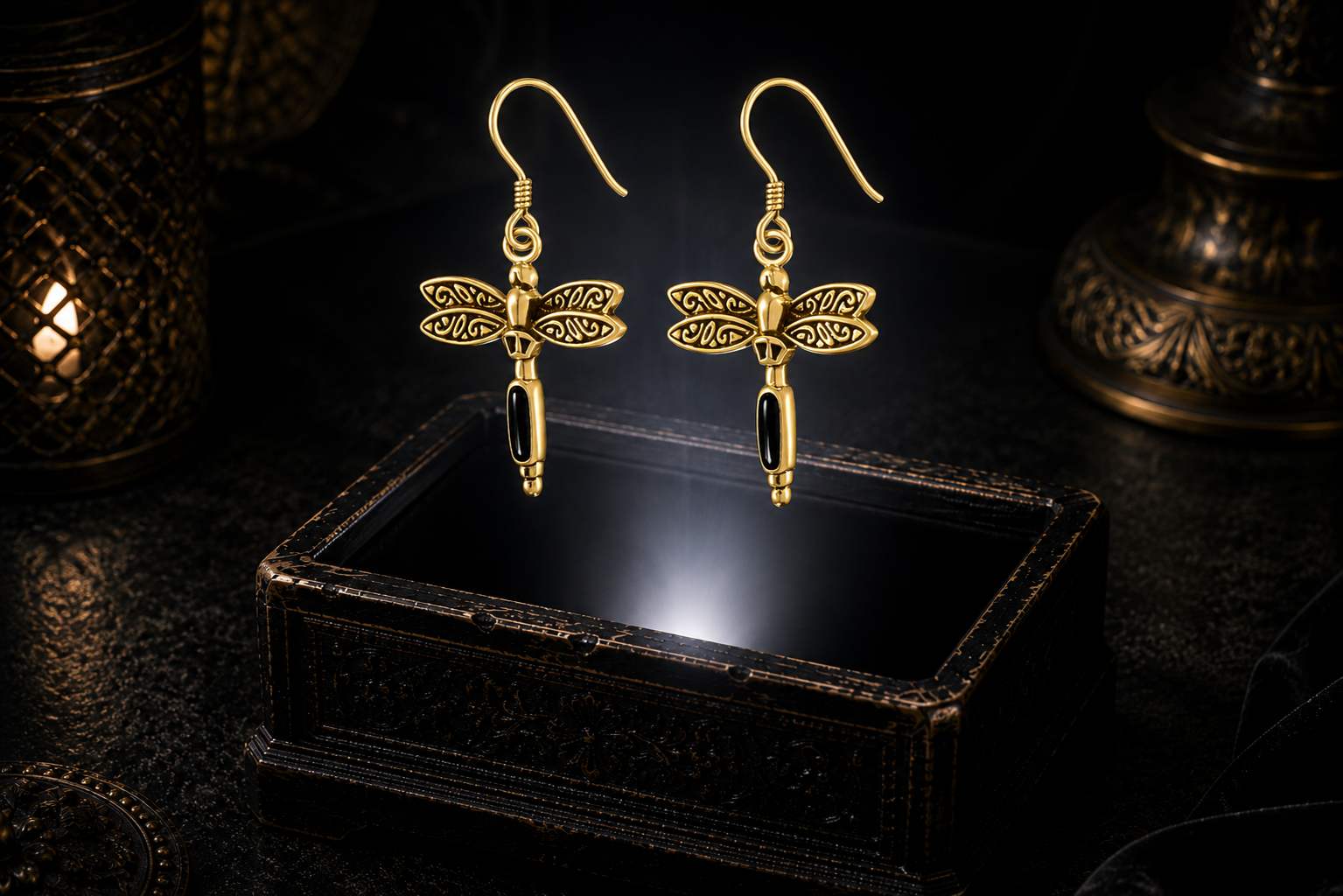 14K solid gold dragonfly earrings with black onyx gemstones floating above a glowing ornate jewelry box in a dark luxurious mystical setting with warm cinematic lighting