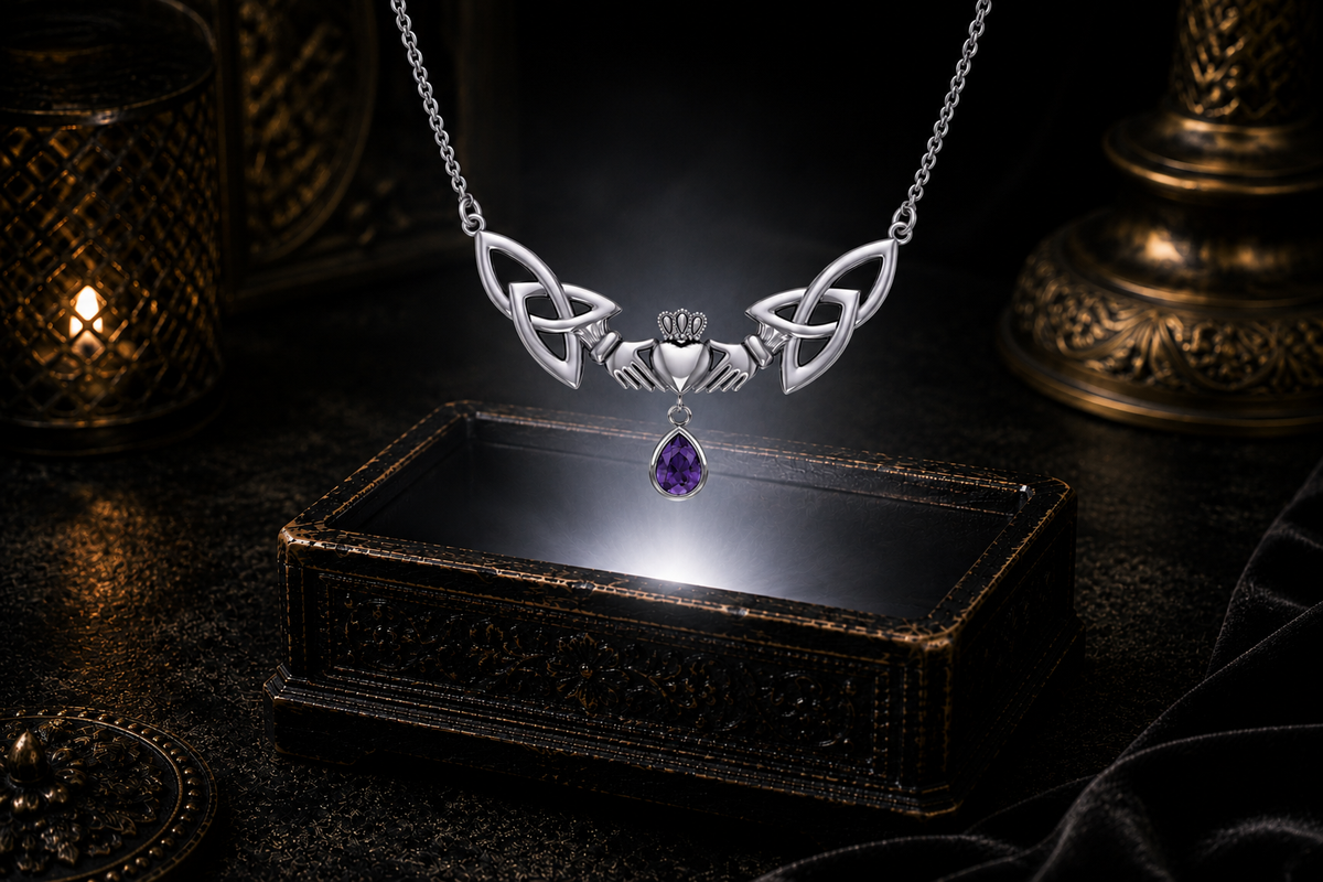 Sterling silver Celtic Claddagh drop necklace with amethyst gemstone accent floating above a glowing ornate jewelry box in a dark cinematic setting