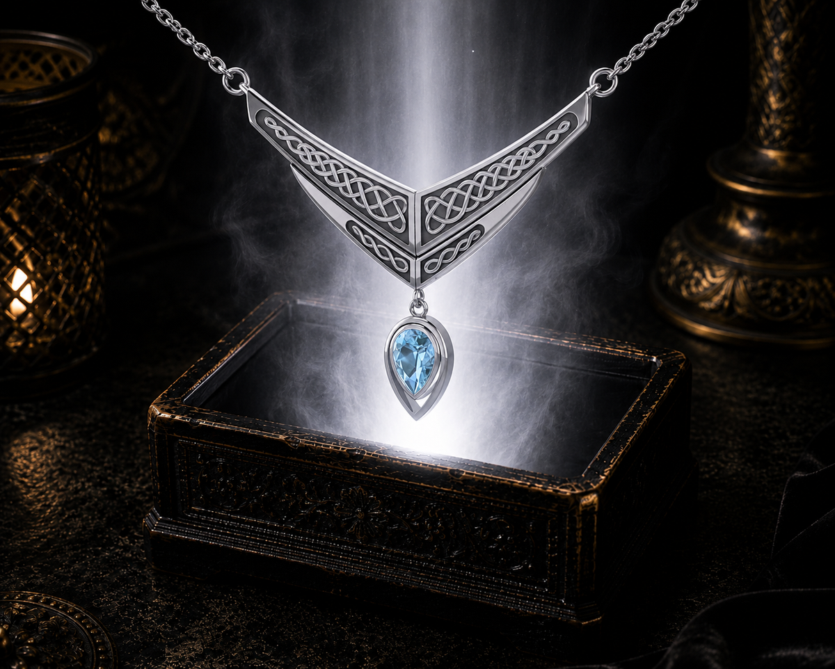 Blue topaz sterling silver Celtic interlace wing necklace illuminated above a luminous jewelry chest against a dark luxury backdrop