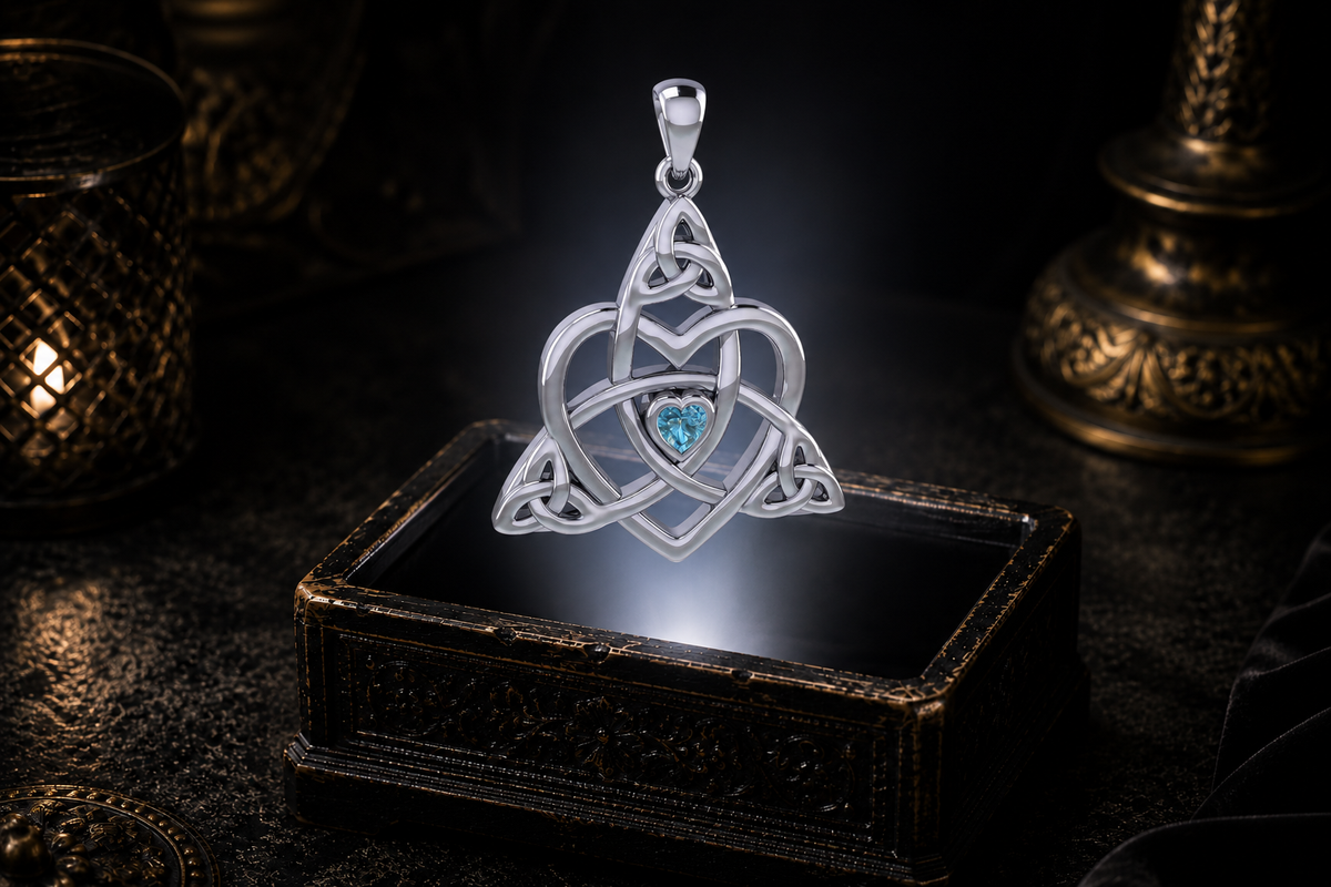 Sterling silver Celtic Trinity heart pendant with a heart-shaped blue topaz hovering over an ornate jewelry box in a dark atmospheric setting