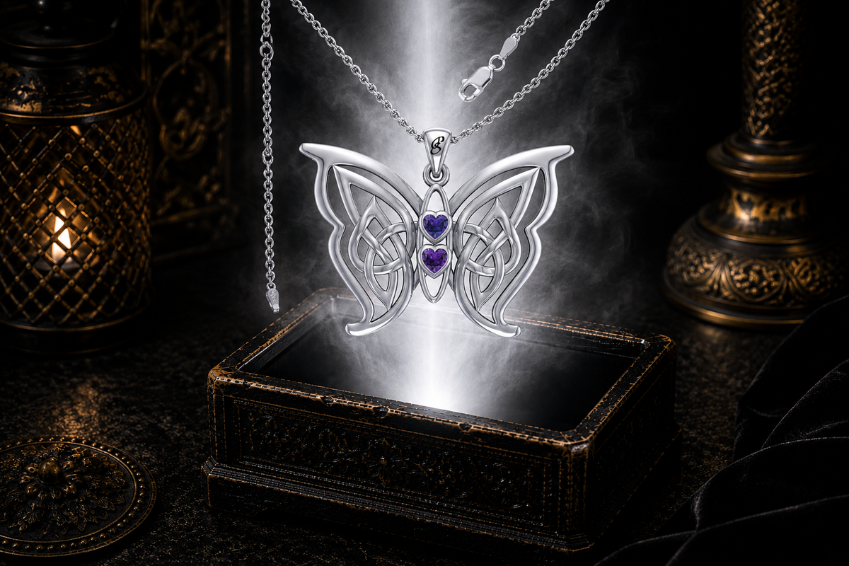 Sterling silver Celtic butterfly pendant with twin amethyst heart gemstones floating above an ornate dark jewelry box surrounded by luminous white light and drifting mist in a cinematic luxury setting.