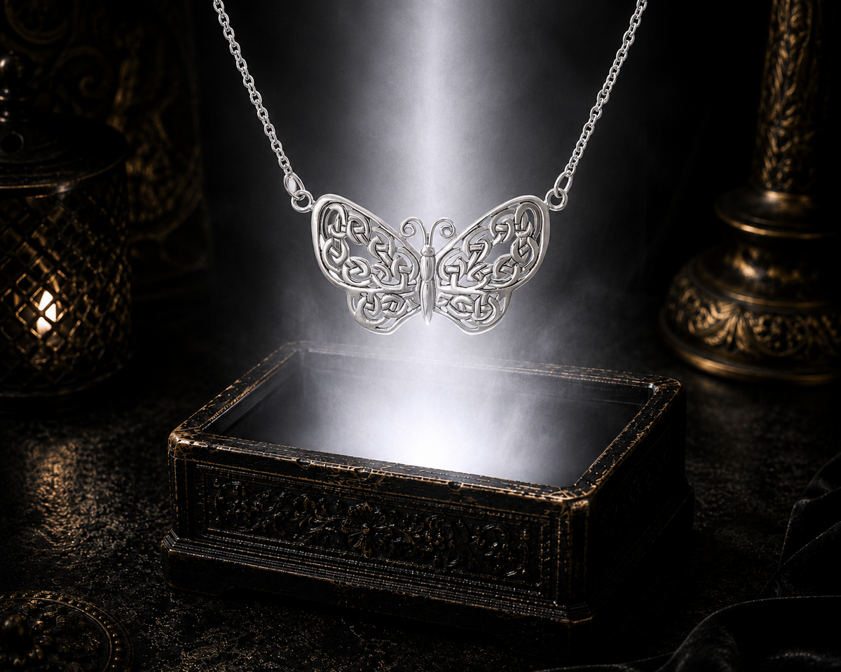 Sterling silver Celtic butterfly necklace floating above an ornate jewelry box beneath soft luminous light in a dark luxury setting with elegant cinematic reflections.