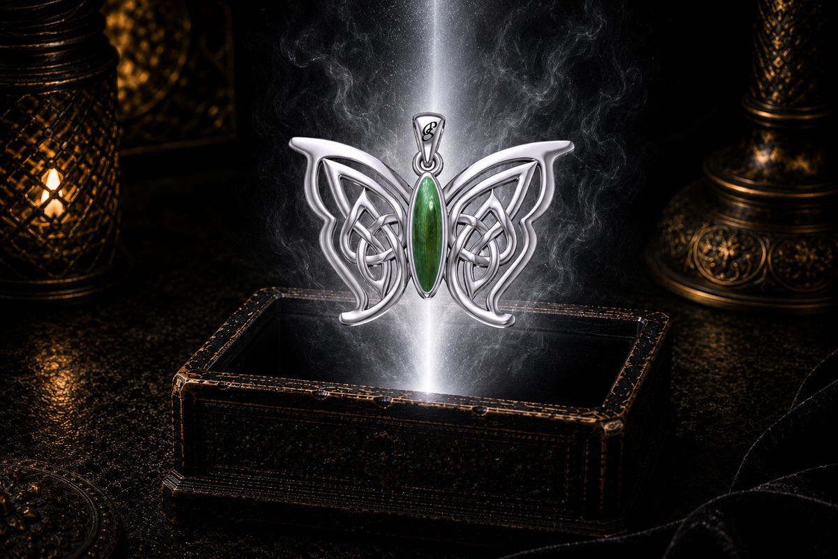 Sterling silver Celtic butterfly pendant with malachite gemstone inlay floating above an ornate dark jewelry box surrounded by luminous white light in a cinematic luxury setting.