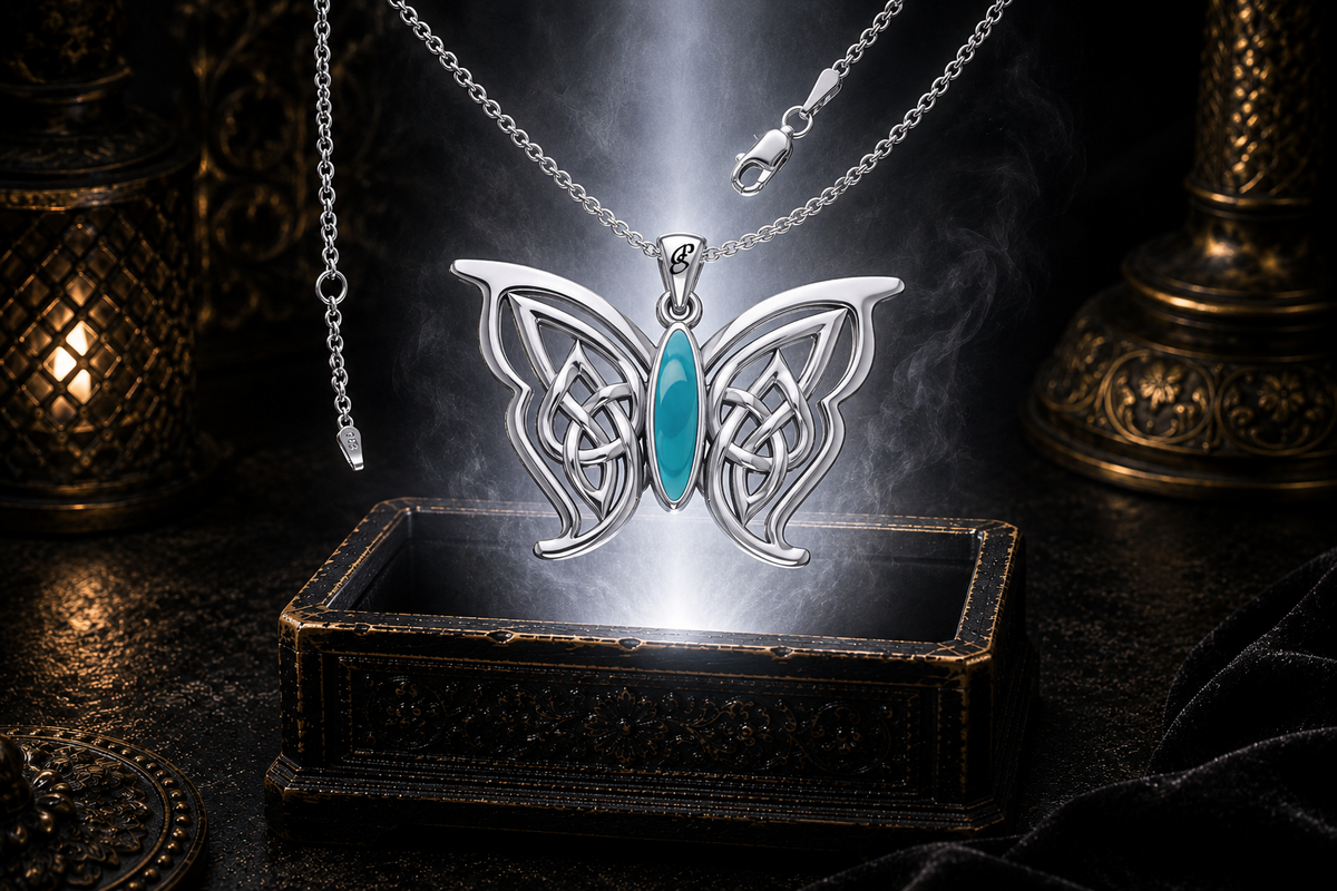 Sterling silver Celtic butterfly pendant with turquoise gemstone inlay floating above an ornate dark jewelry box surrounded by luminous white light in a cinematic luxury setting.