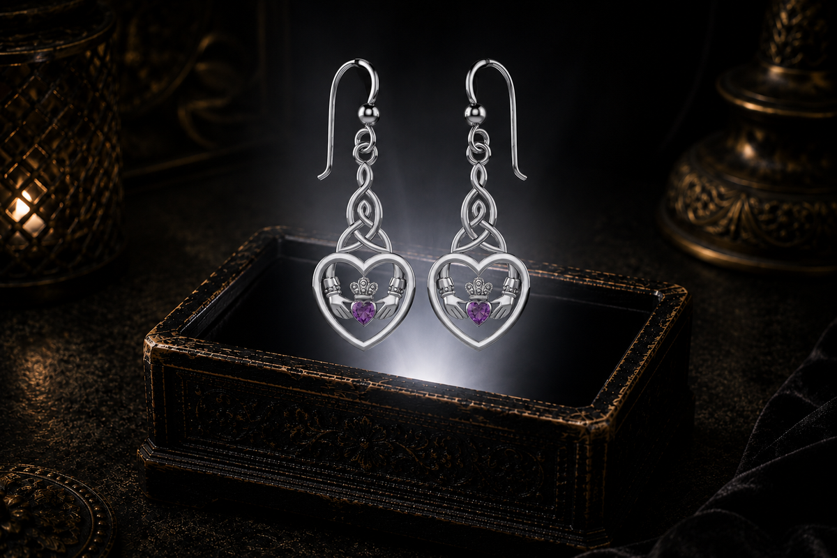 Sterling silver Celtic Claddagh Trinity knot heart earrings with amethyst gemstones floating above a glowing ornate jewelry box in a dark luxury setting