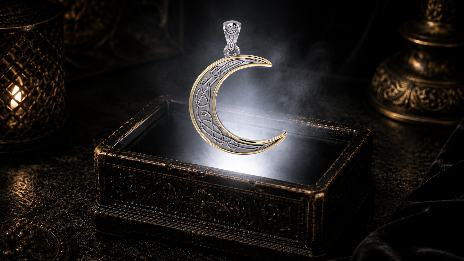 Sterling silver Celtic crescent moon pendant with 14K gold accent and intricate Celtic knotwork floating above an ornate black jewelry box illuminated by soft white light, surrounded by subtle mist in a dark luxury celestial setting.