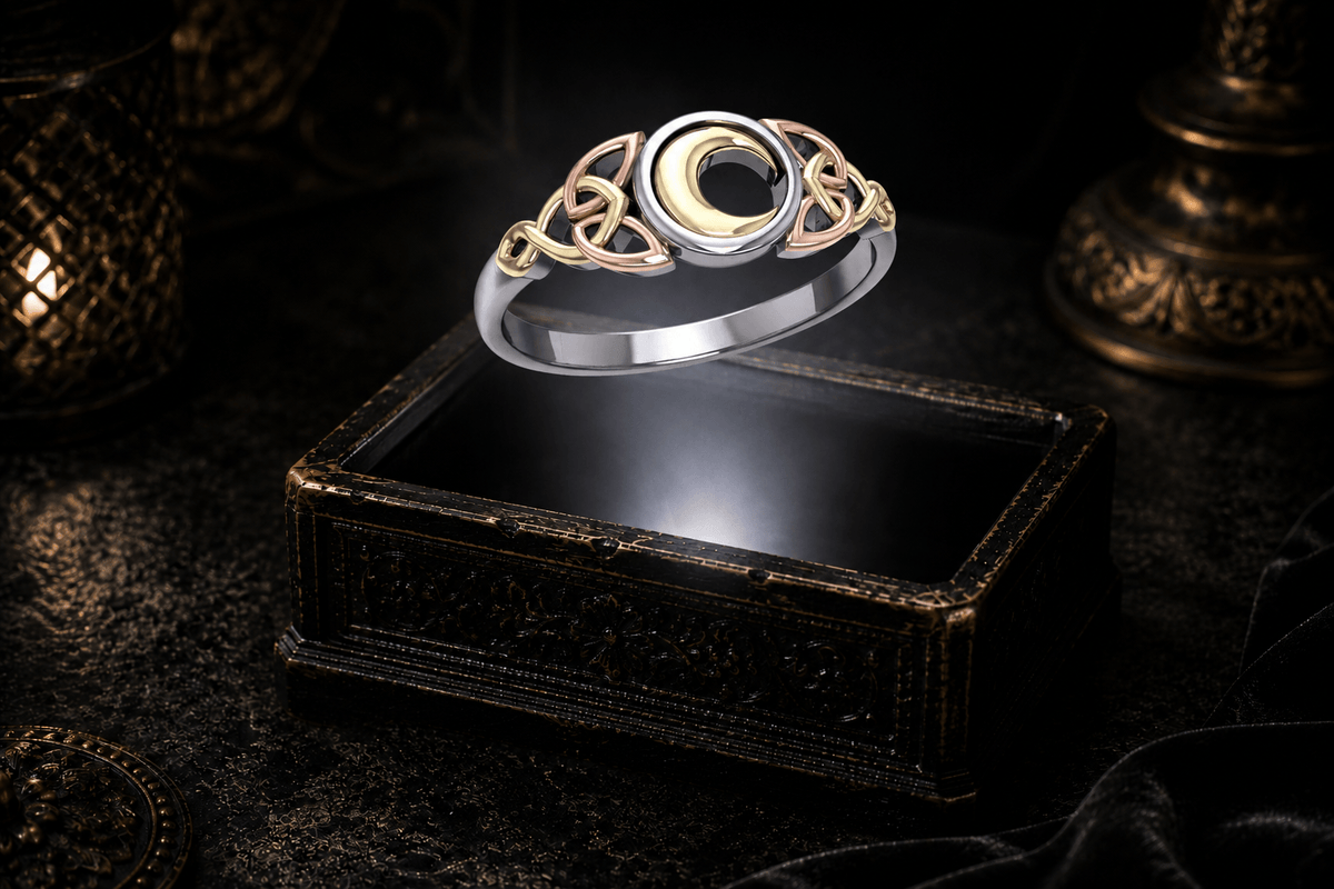 Celtic crescent moon and Trinity knot ring hovering above an ornate dark jewelry box in a neutral white beam of light.