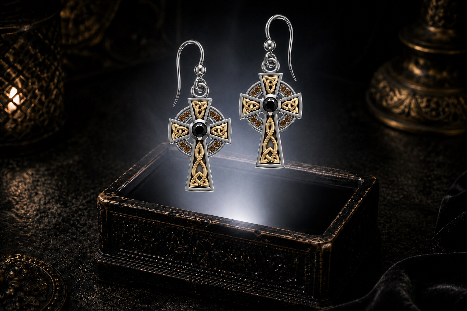 Sterling silver Celtic cross earrings with black and cognac cubic zirconia accents floating above a glowing ornate jewelry box in a dark luxury setting