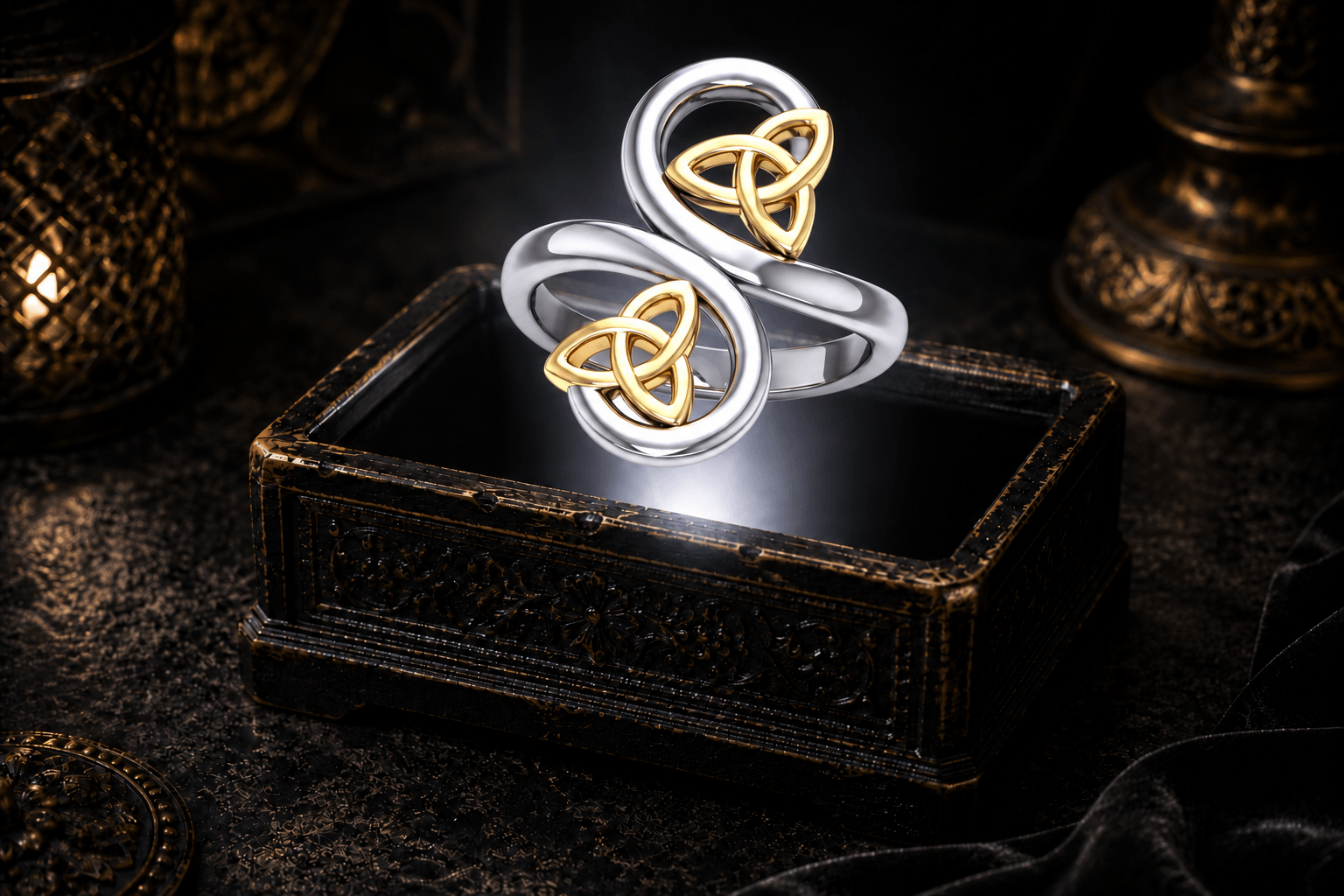 Celtic double Trinity knot ring in .925 sterling silver with two 14K gold Trinity knot accents, floating above an ornate black jewelry box.