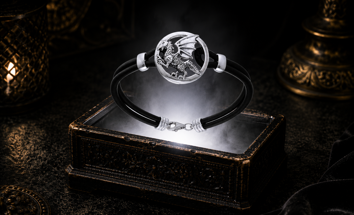 Sterling silver dragon leather cord bracelet with a Celtic dragon medallion displayed above an antique luxury jewelry chest in a refined mythic setting with dramatic lighting and soft atmospheric mist.