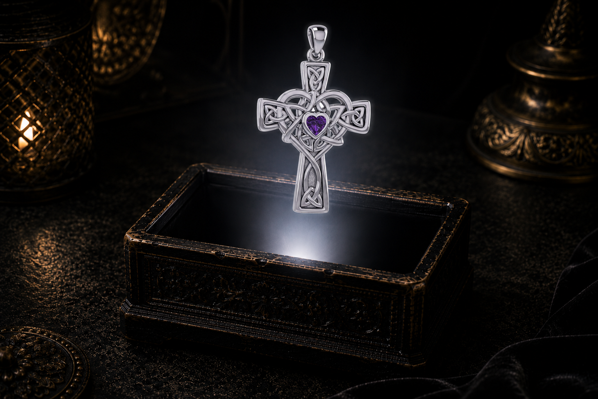Sterling silver Celtic Heart Cross pendant featuring a heart-shaped Amethyst gemstone floating within a soft beam of light above an ornate keepsake box.