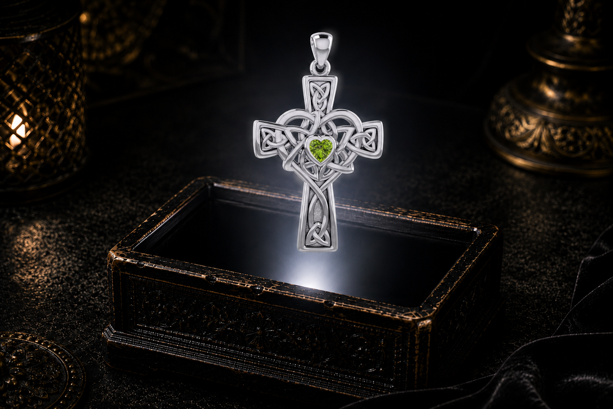 Sterling silver Celtic Heart Cross pendant showcasing a heart-shaped Peridot gemstone against a dark luxury backdrop with glowing candlelight.