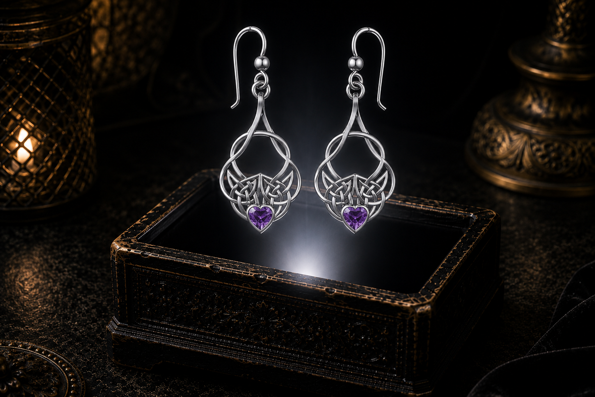 Sterling silver Celtic heart knot earrings with amethyst heart gemstones floating above a glowing ornate jewelry box in a dark luxurious mystical setting