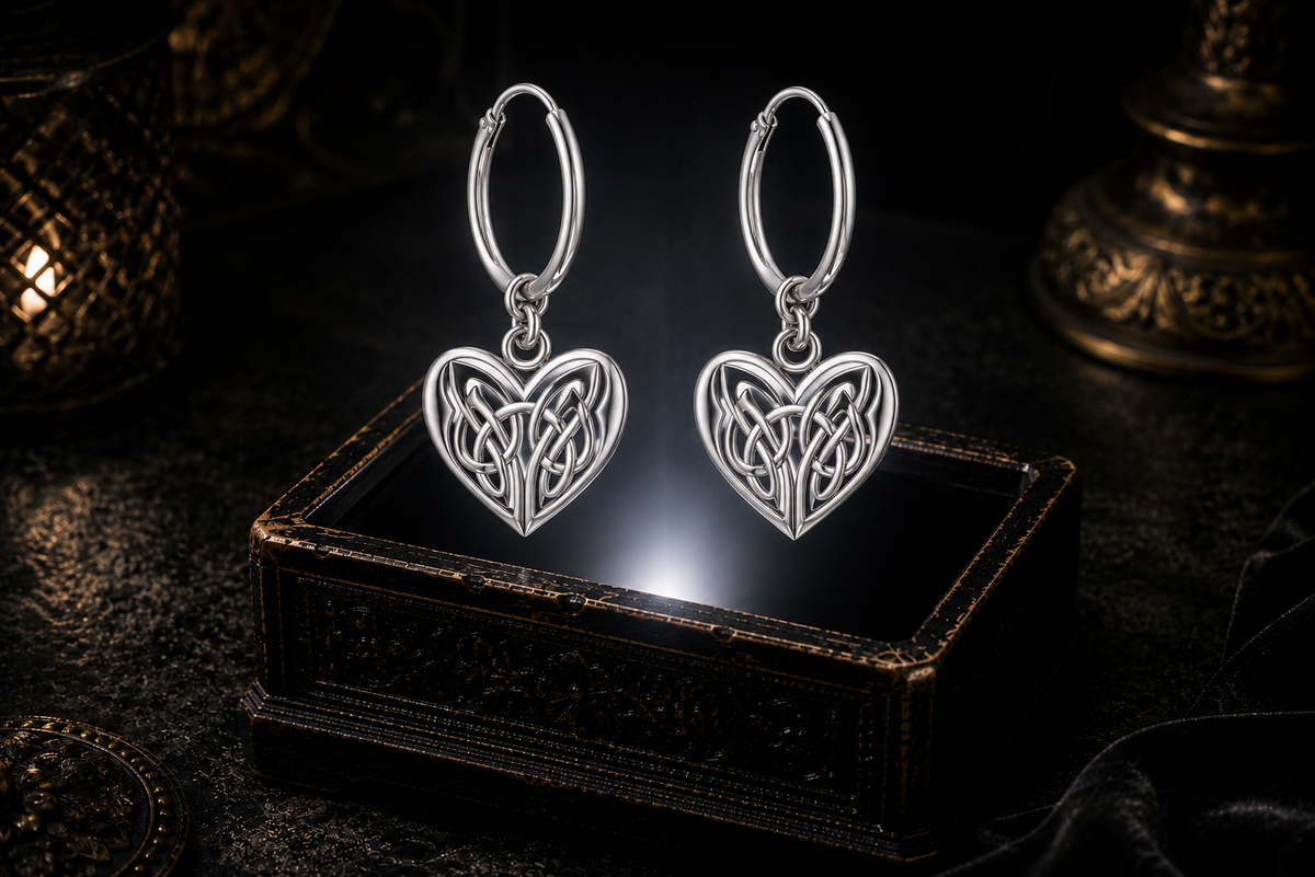 Sterling silver Celtic heart knot hoop earrings floating above a glowing ornate jewelry box in a dark luxurious mystical setting with cinematic lighting