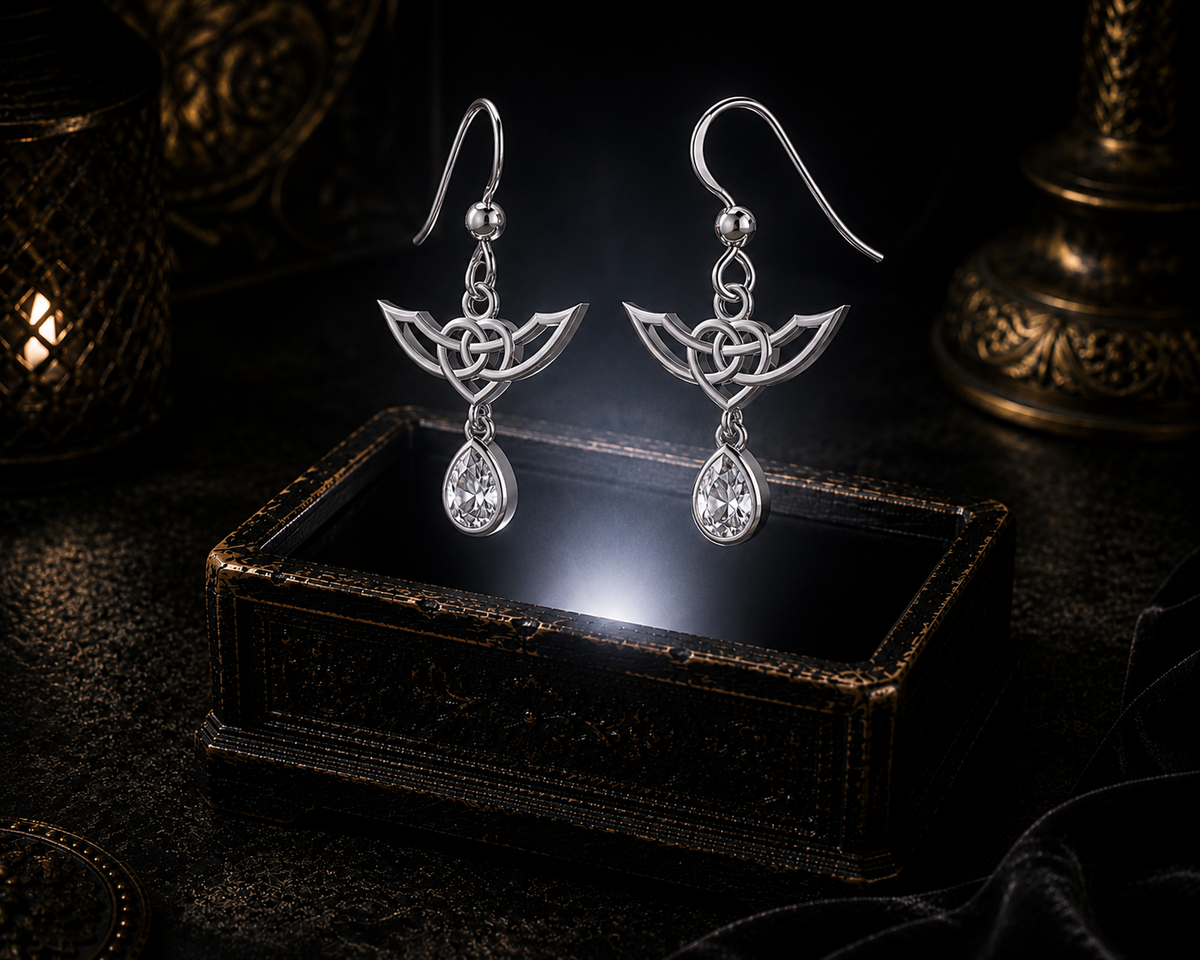Sterling silver Celtic Infinity Knot earrings with dangling cubic zirconia gemstones floating above a glowing ornate jewelry box in a dark luxurious mystical setting with cinematic lighting