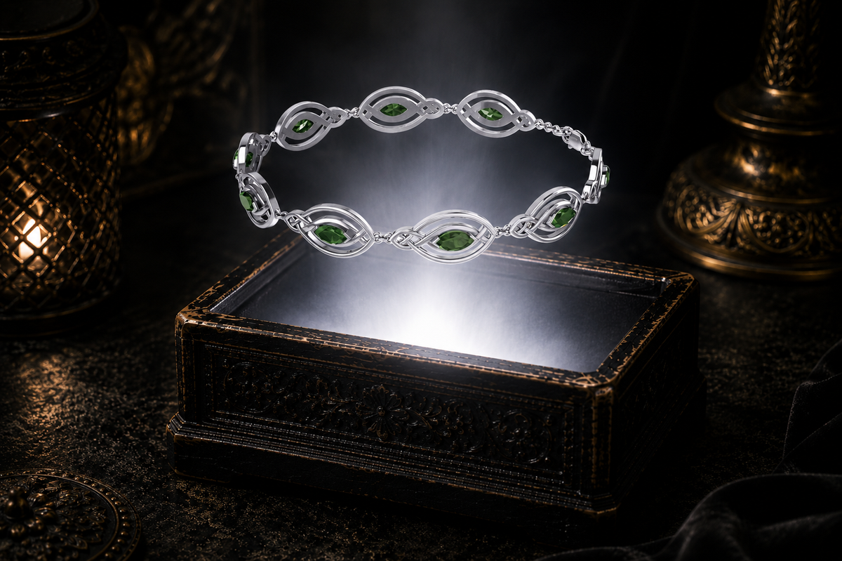 Sterling silver Celtic knot bracelet with emerald glass marquise gemstones floating above an ornate black jewelry box surrounded by subtle mist in a dark luxury environment.