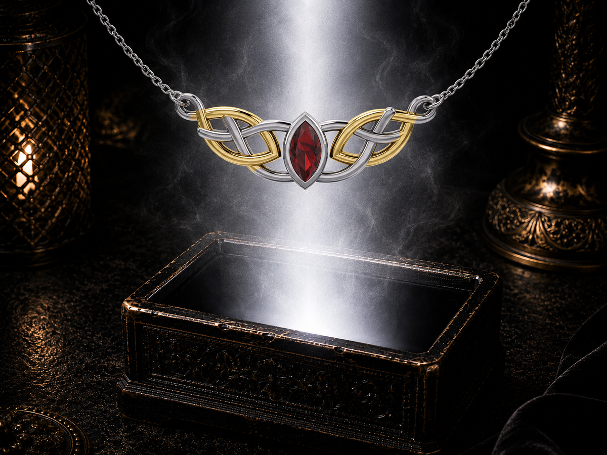 Sterling silver Celtic knotwork necklace with 14K gold accents and garnet gemstone suspended above an ornate jewelry box in a dark luxury environment with elegant reflections and soft glow.