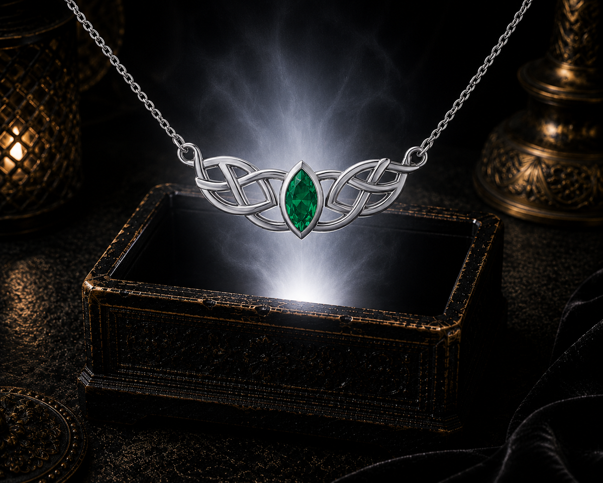 Celtic sterling silver gemstone necklace with emerald glass centerpiece floating in a mystical luxury scene above a glowing jewelry box