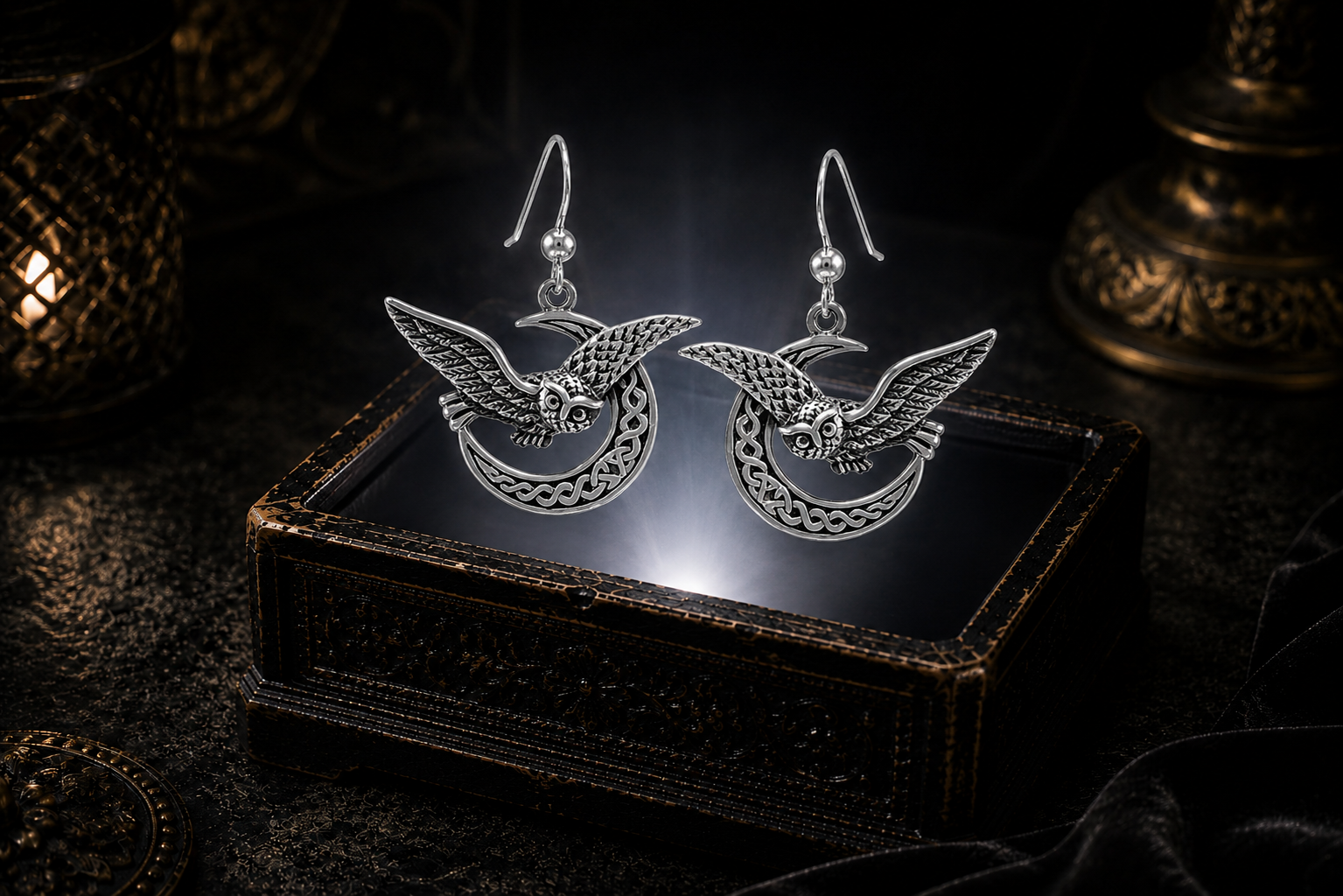 Sterling silver Celtic owl crescent moon earrings floating above a glowing ornate jewelry box in a dark luxurious mystical setting with cinematic lighting