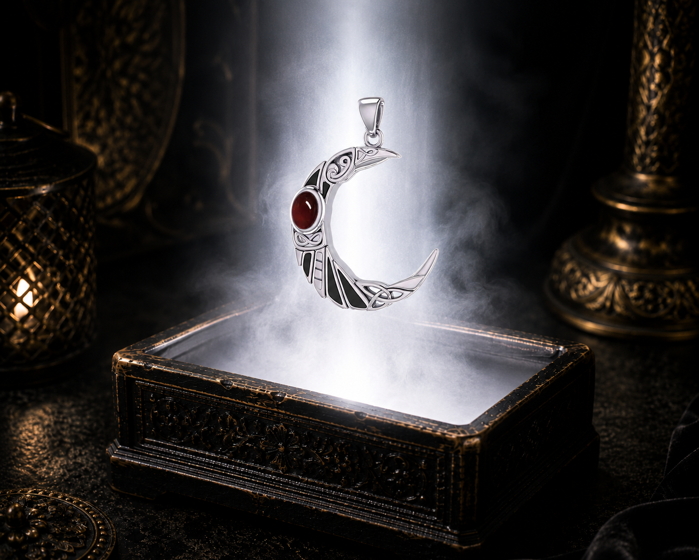 Sterling silver Celtic raven crescent moon pendant with garnet gemstone floating above an ornate antique jewelry box illuminated by soft white light in a cinematic luxury environment with black enamel details.