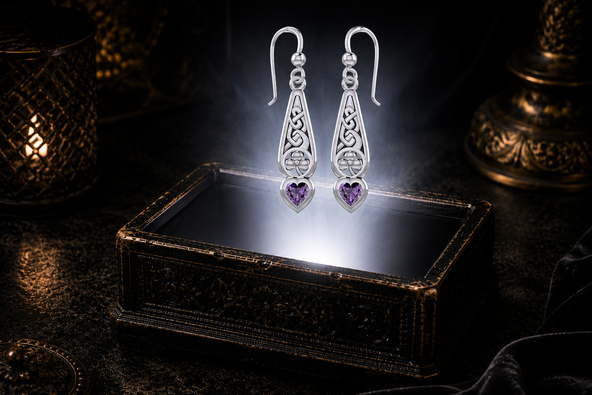 Sterling silver Celtic knot shamrock earrings with heart-shaped amethyst gemstones displayed above an antique jewelry chest surrounded by cinematic shadows and refined luxury details.