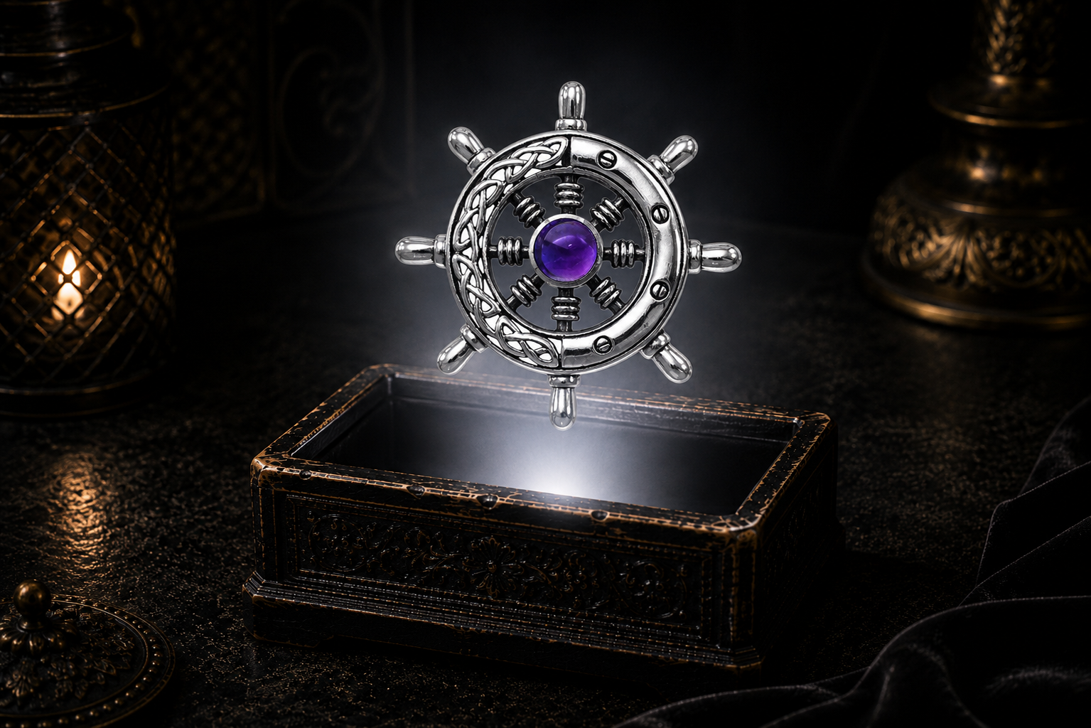 Sterling silver Celtic ship wheel pendant with blue topaz gemstone floating above an ornate black jewelry box with soft white glow, candlelit accents, and a dark luxury maritime-inspired setting.