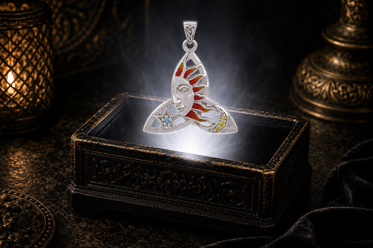 Sterling silver Celtic Sun Moon Star Trinity Knot pendant featuring a radiant red and orange enamel sun, a genuine 2 mm Blue Topaz star, and a crescent moon accented with three 1.5 mm yellow CZ stones, floating above an illuminated antique jewelry box in a cinematic luxury setting.