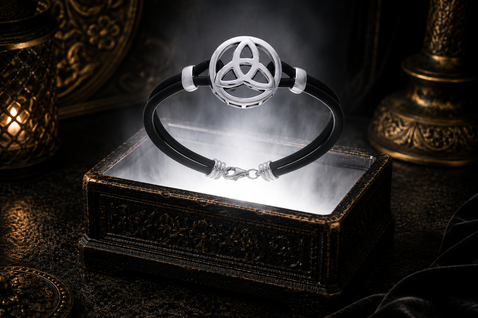Sterling silver Triquetra leather bracelet displayed above an antique jewelry chest surrounded by luminous white light in a refined mystical luxury environment.