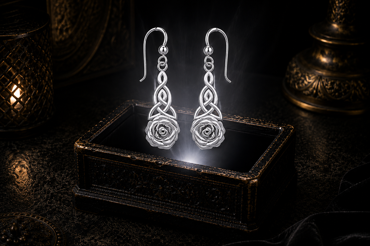 Sterling silver Celtic Trinity knot rose earrings floating above a glowing ornate jewelry box in a dark luxury setting