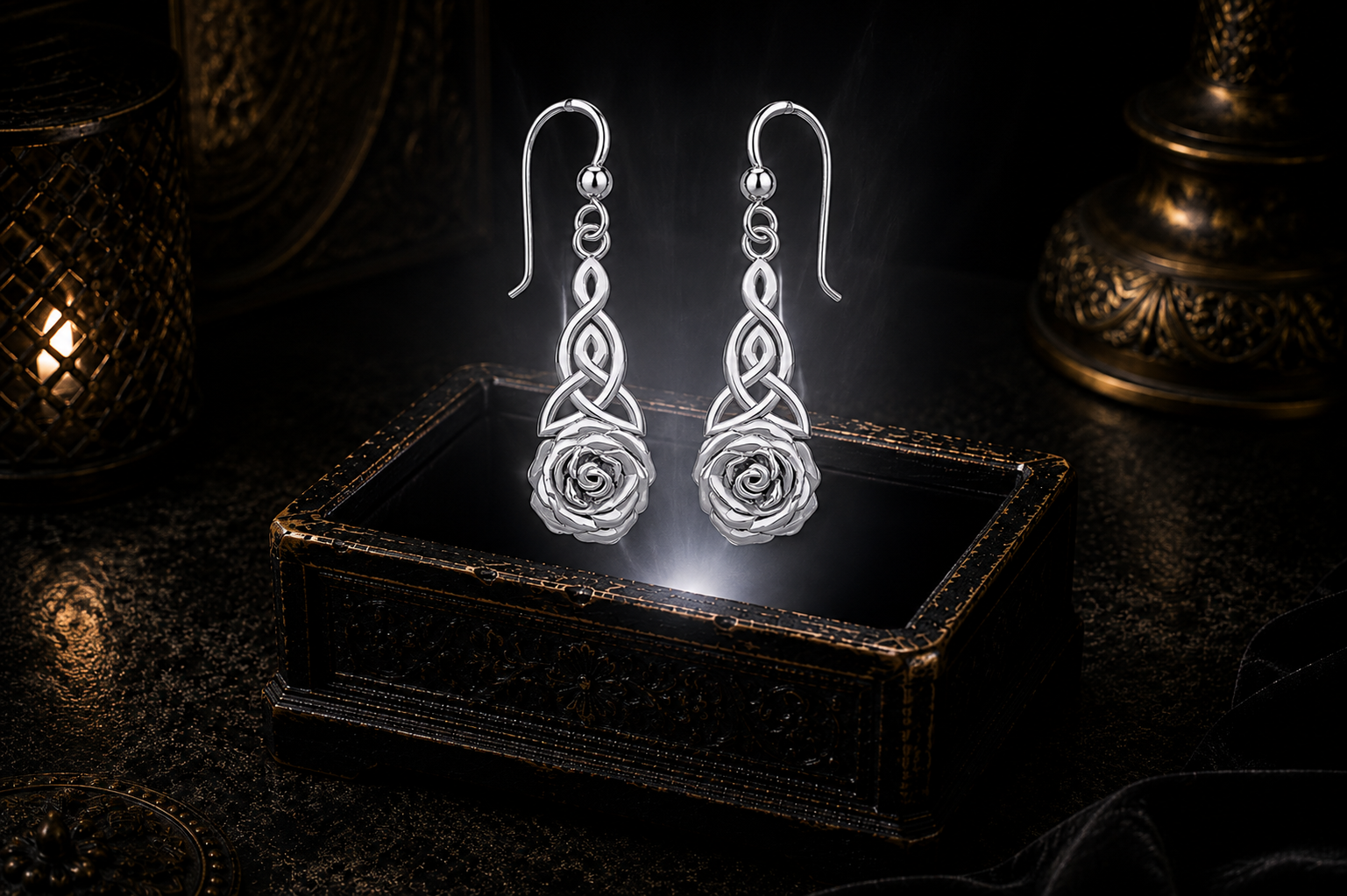 Sterling silver Celtic Trinity knot rose earrings floating above a glowing ornate jewelry box in a dark luxury setting