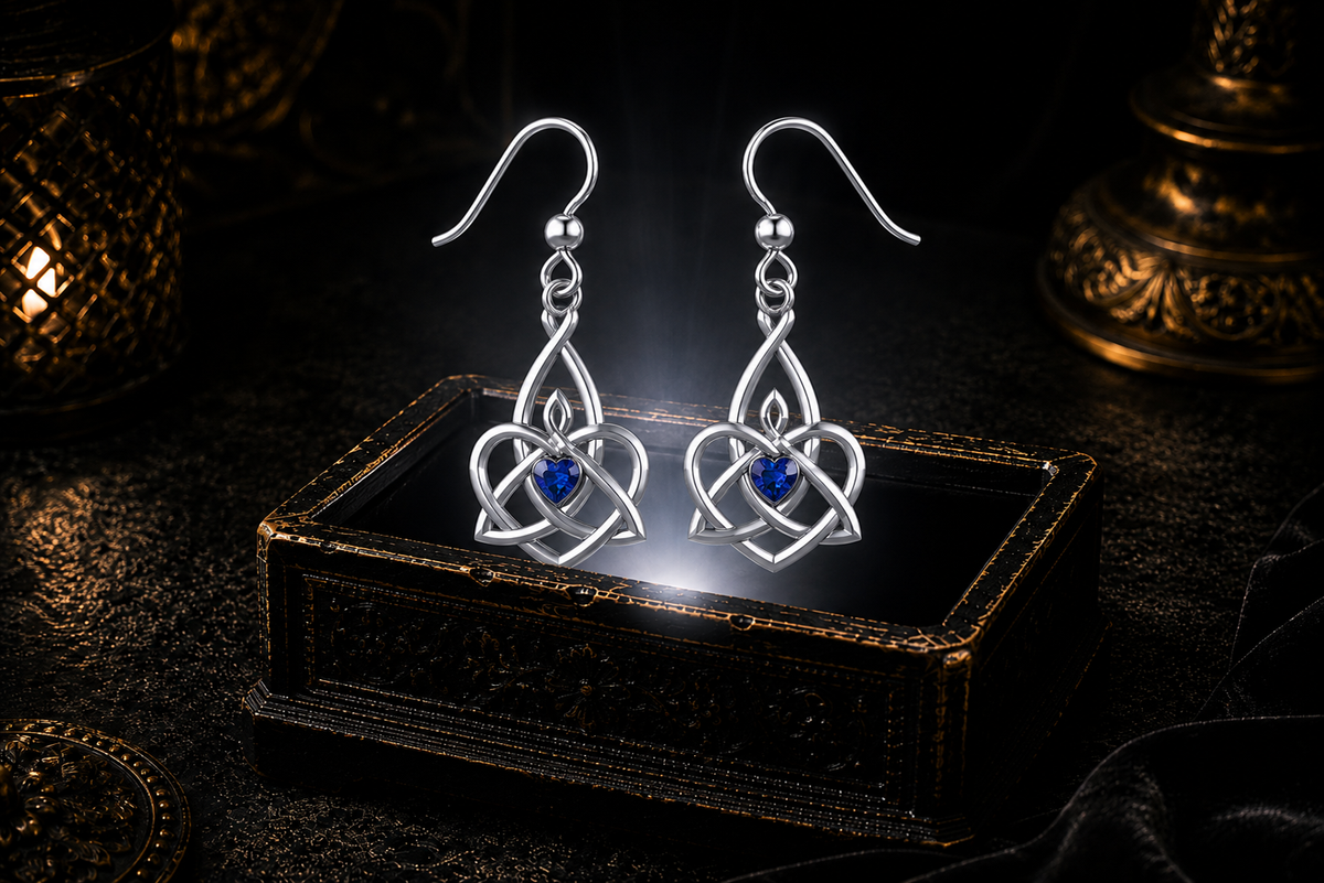 Sterling silver Celtic Triquetra Trinity Knot heart earrings with sapphire heart gemstones floating above a glowing ornate jewelry box in a dark luxurious mystical setting with cinematic lighting