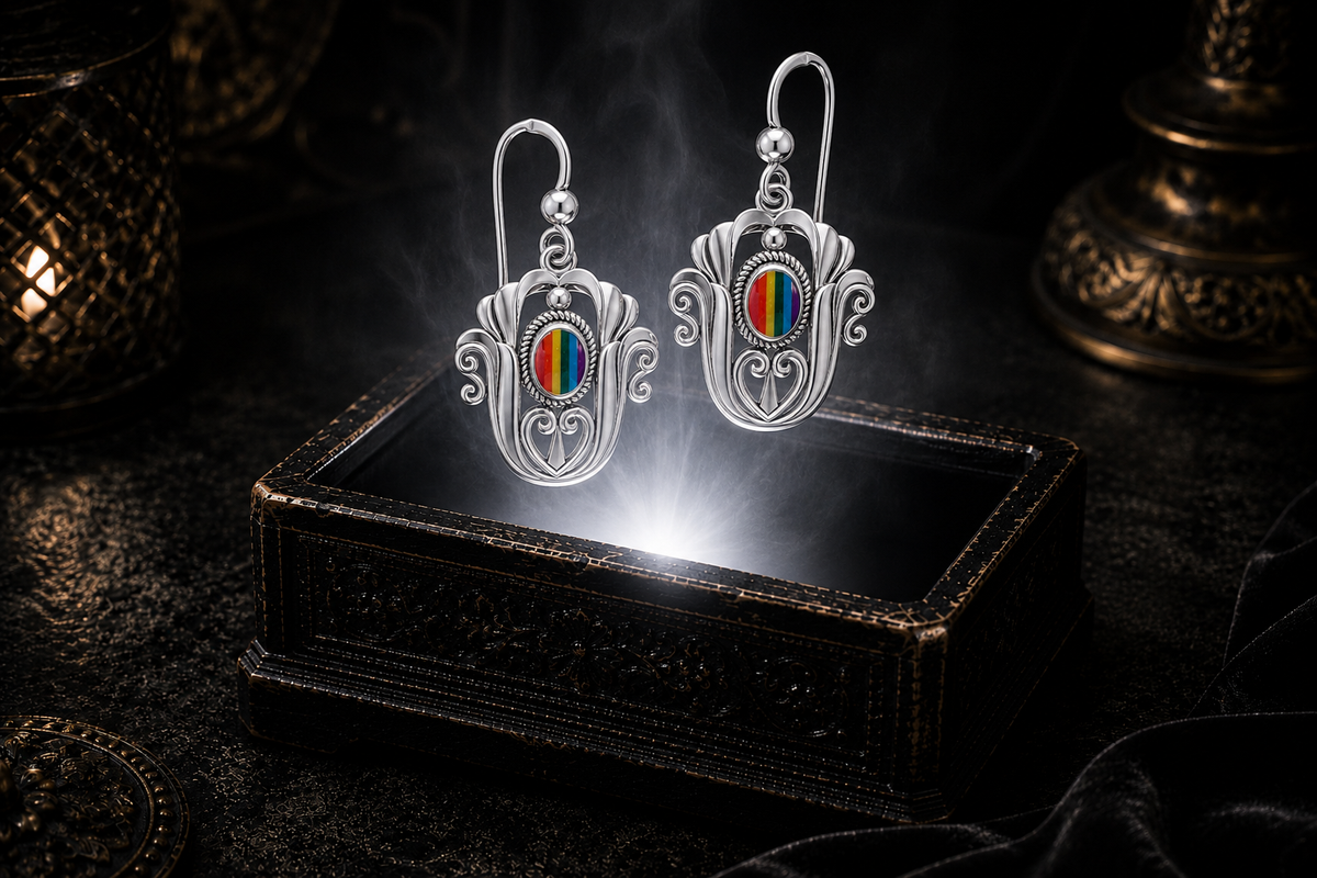 Sterling silver Celtic triquetra tulip earrings with rainbow stripe gemstones floating above a glowing ornate jewelry box in a dark luxury setting