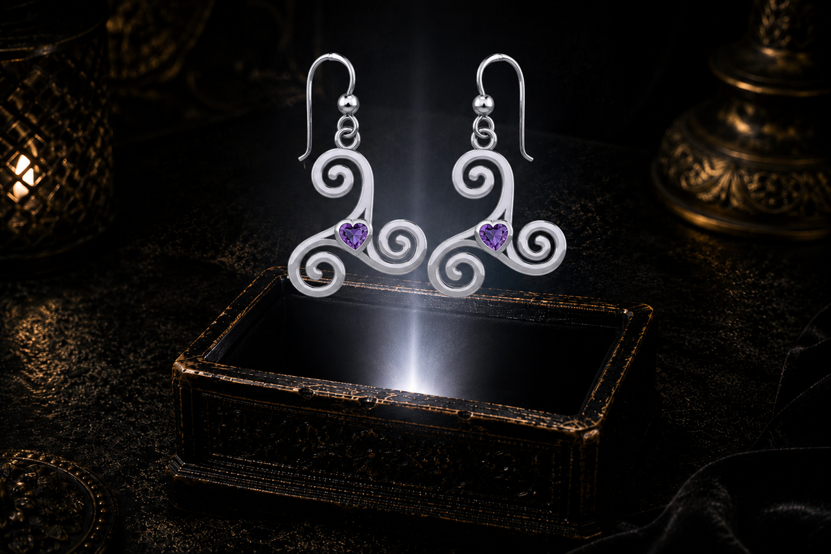 Sterling silver Celtic triskele spiral earrings with amethyst heart gemstones floating above a glowing ornate jewelry box in a dark luxury setting