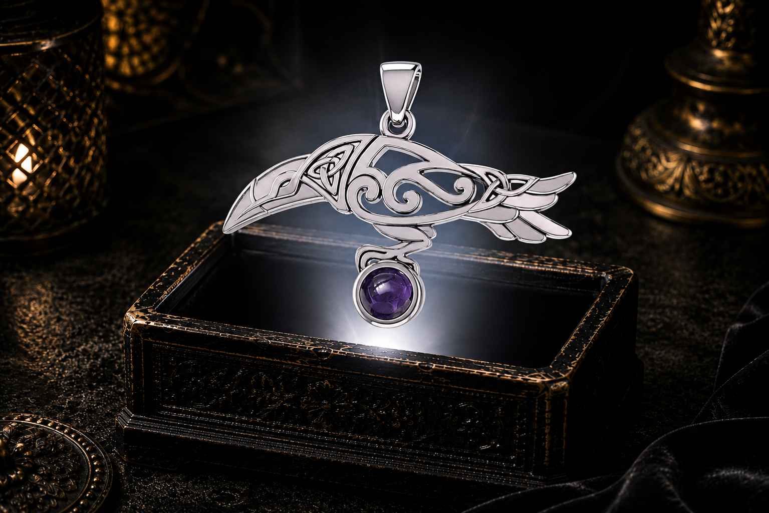 Sterling silver Celtic raven pendant with garnet cabochon gemstone showcased above an ornate jewelry box surrounded by warm cinematic light and mystical ambiance.