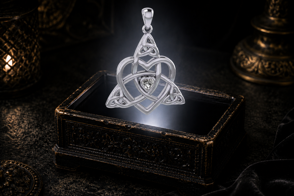 Sterling silver Celtic heart pendant with Trinity knotwork and a clear heart-shaped cubic zirconia floating above an illuminated antique jewelry box