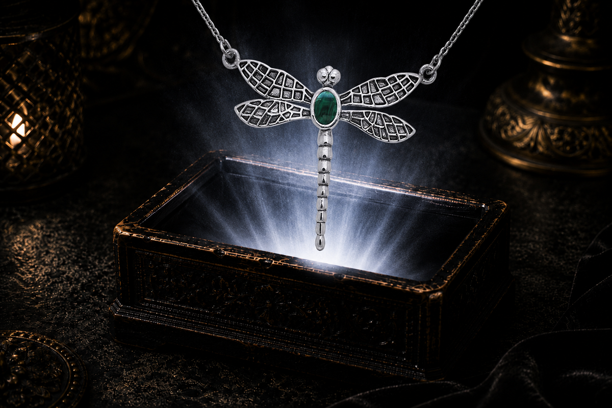 Dragonfly sterling silver necklace with malachite gemstone floating in a mystical luxury scene above a glowing jewelry box