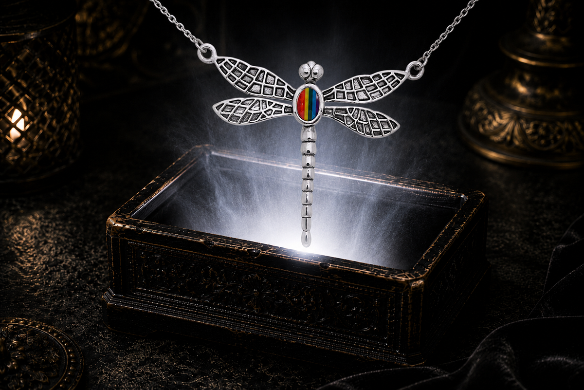 Sterling silver dragonfly pendant with rainbow gemstone floating above a luminous jewelry chest in a dark mystical setting