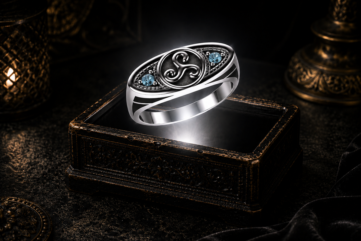 Sterling silver ellipse triskele ring with blue topaz gemstone studs illuminated above an antique jewelry box with cinematic lighting