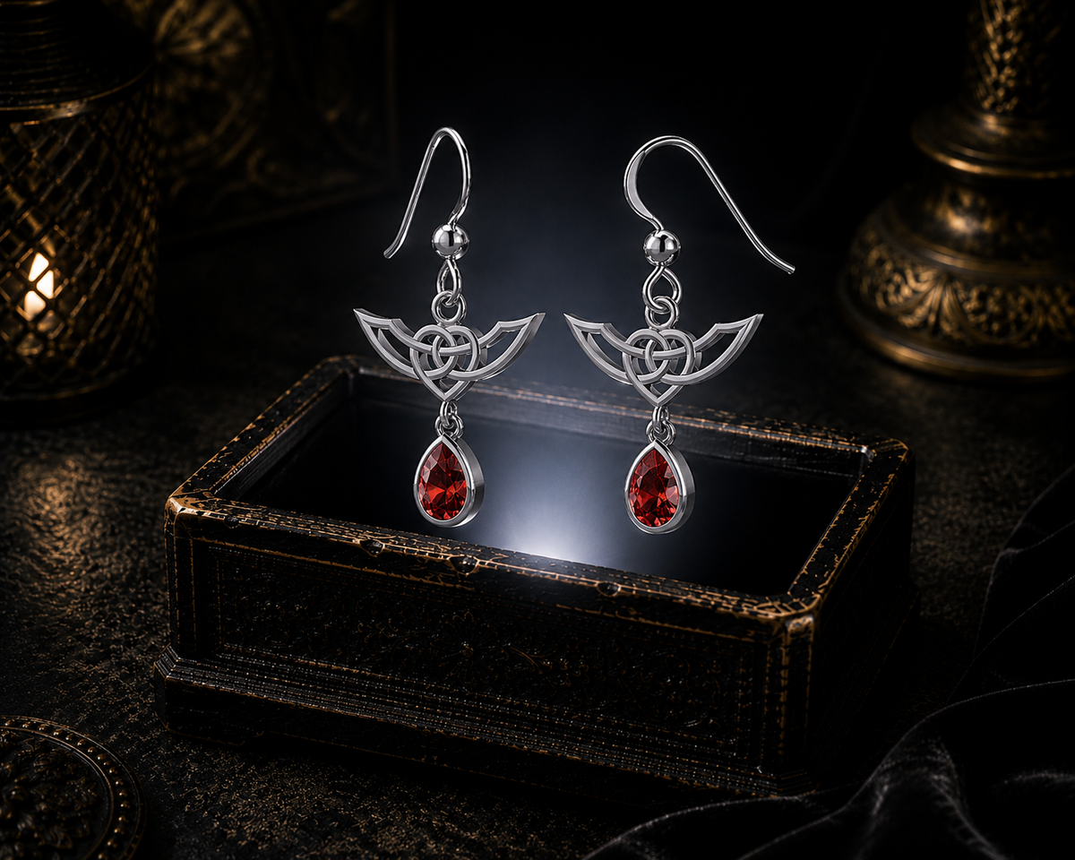 Sterling silver Celtic Infinity Knot earrings with dangling garnet gemstones floating above a glowing ornate jewelry box in a dark luxurious mystical setting with cinematic lighting