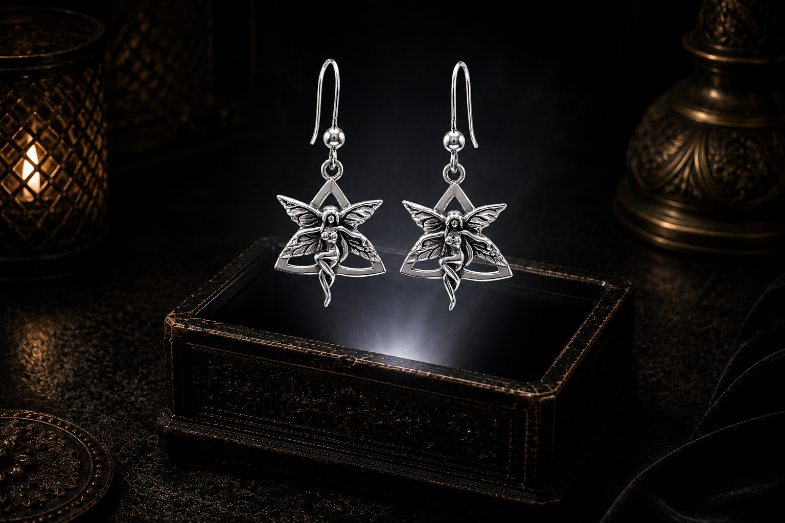 Sterling silver Celtic fairy Triquetra earrings floating above a glowing ornate jewelry box in a dark luxury setting