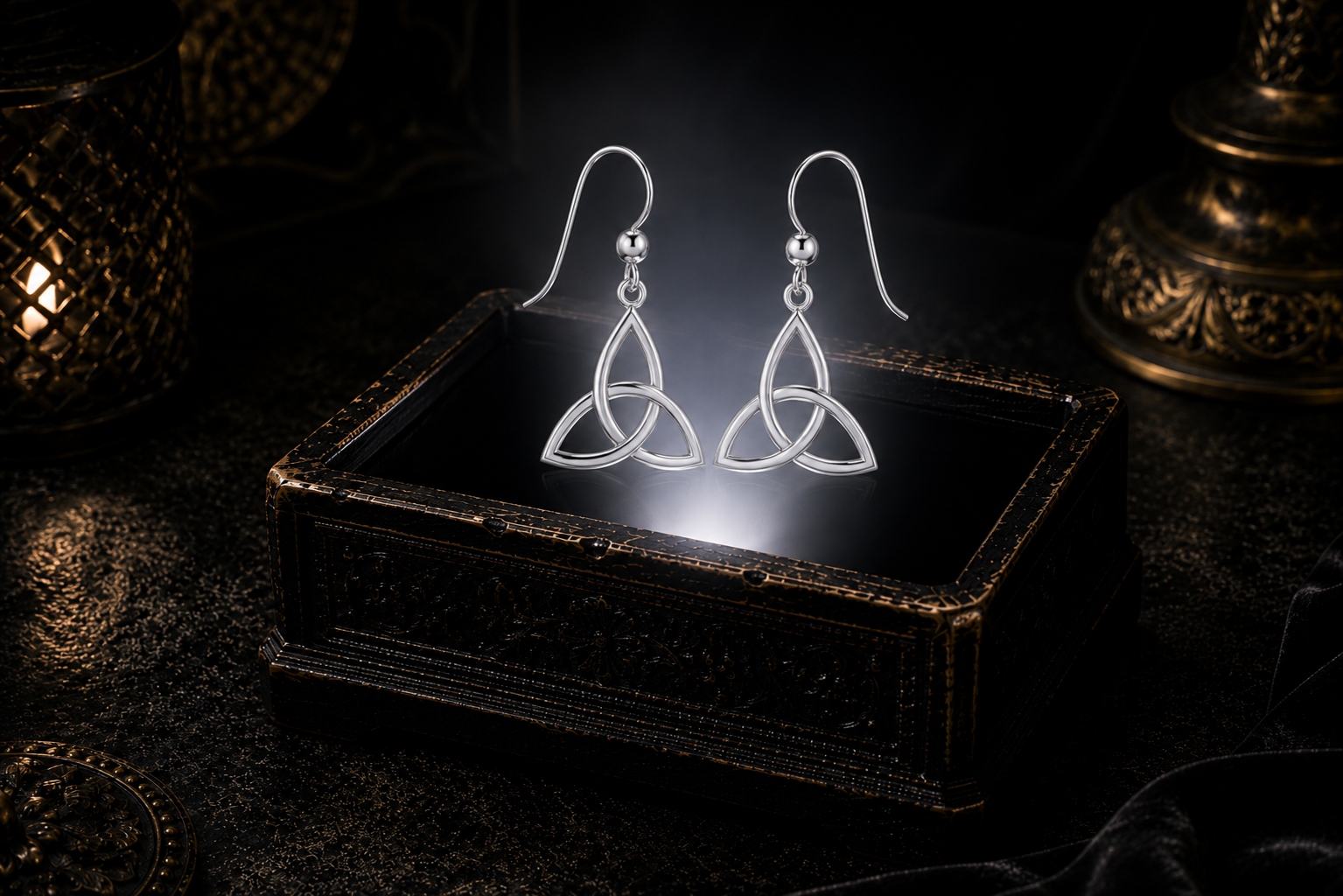 Sterling silver Celtic triquetra dangle earrings in an elegant minimalist setting with reflective silver detailing