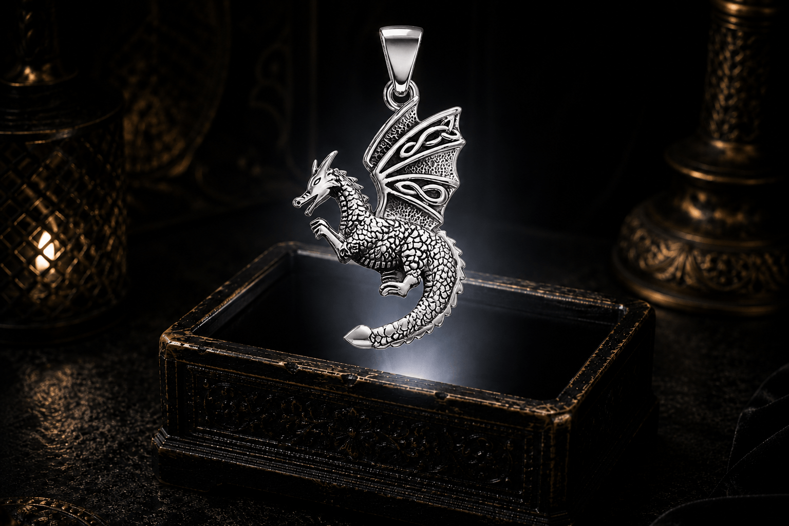 Sterling silver flying dragon pendant with detailed scales, raised forelegs, curled tail, a Trinity knot in the upper wing, and Celtic knotwork below.