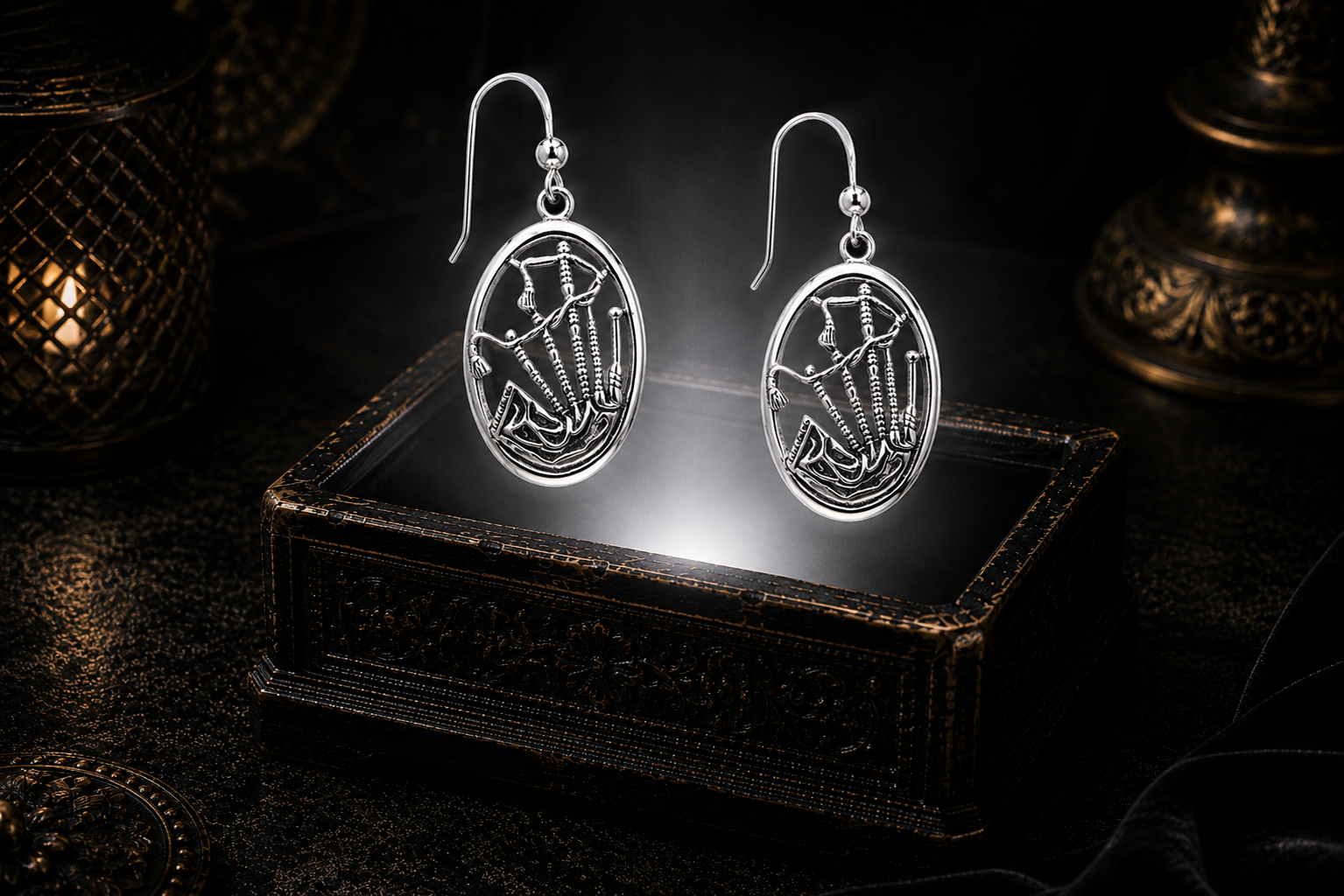 Sterling silver Highland bagpipes Celtic earrings floating above a glowing ornate jewelry box in a dark luxury setting
