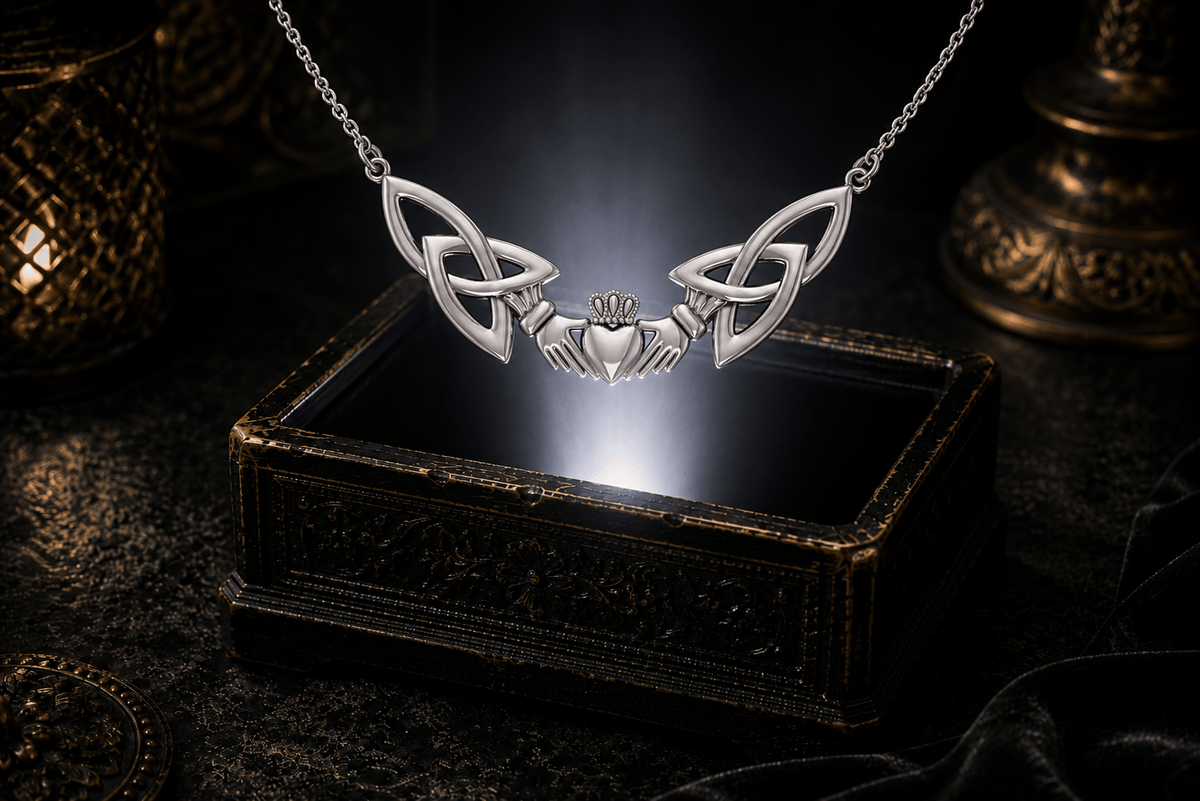 Sterling silver Irish Claddagh necklace with Celtic Trinity Knots floating above an antique jewelry box in a cinematic luxury setting.