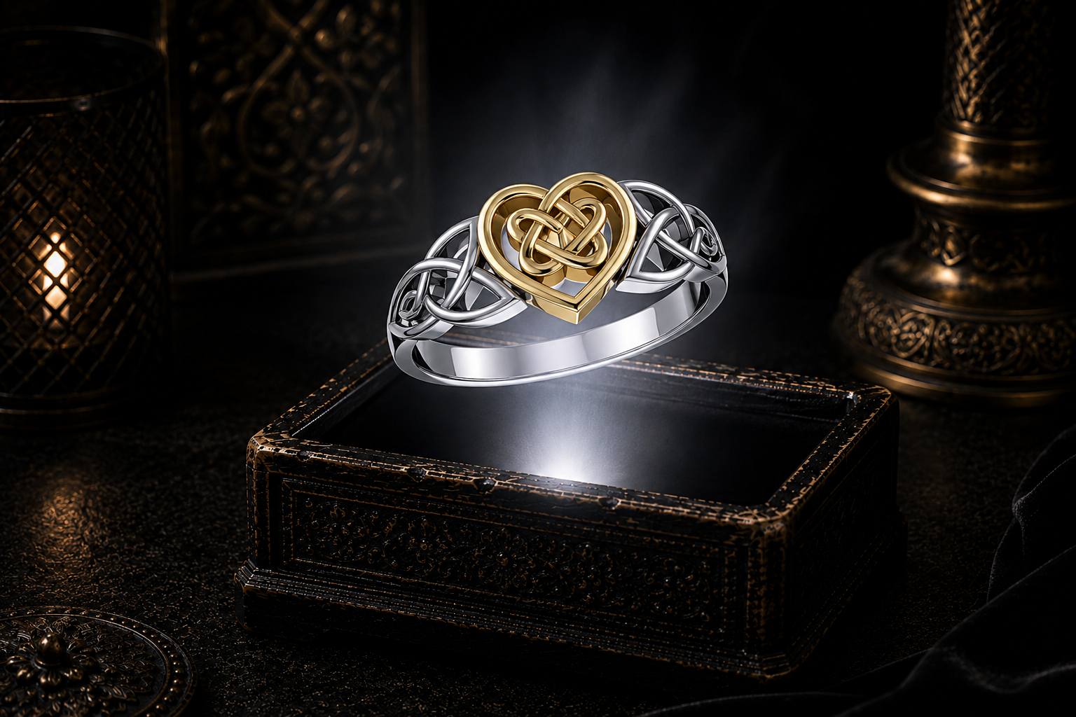 Sterling silver knotted heart Celtic ring with 14K gold heart accent floating above a glowing antique jewelry box in a cinematic luxury setting