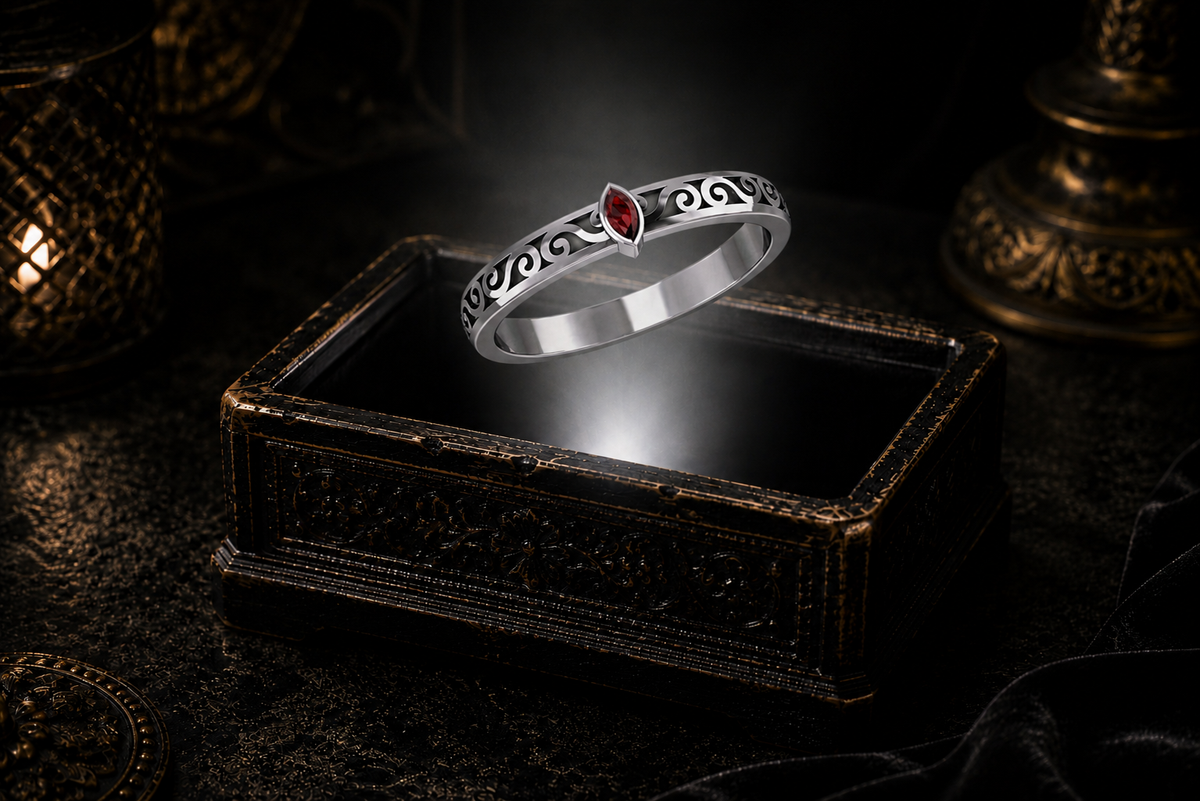 Garnet marquise sterling silver filigree ring hovering above an antique jewelry box surrounded by soft atmospheric lighting.
