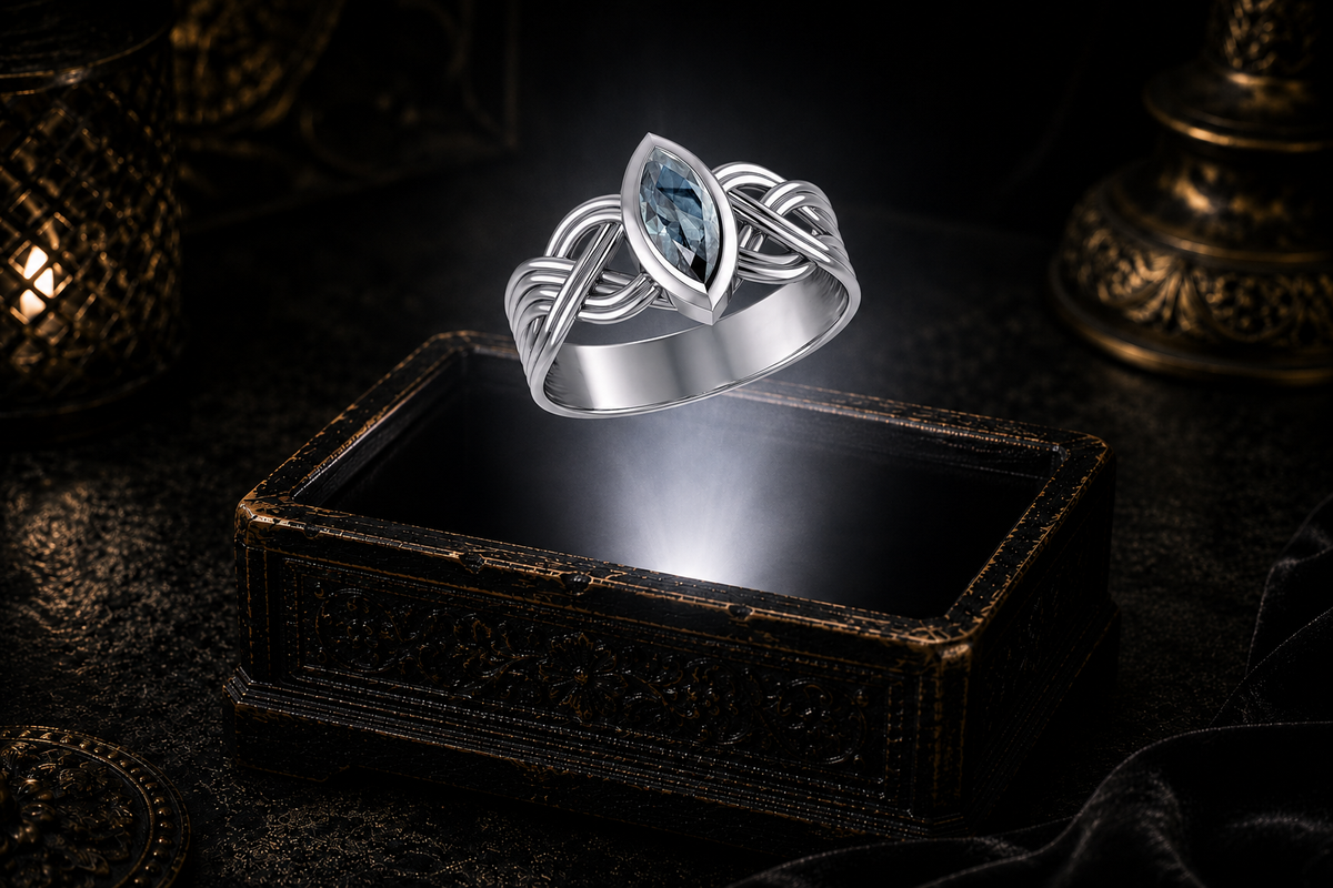 Sterling silver Celtic interwoven strand ring featuring a marquise-cut blue topaz suspended above an ornate keepsake box against a refined luxury backdrop with warm ambient lighting.