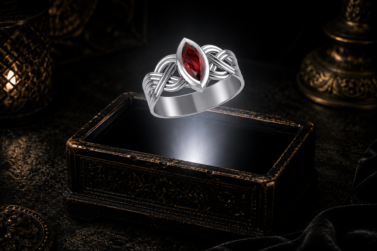 Sterling silver Celtic interwoven strand ring with a marquise-cut garnet showcased above an antique jewelry chest in a dramatic macro jewelry scene with a neutral white beam of light.